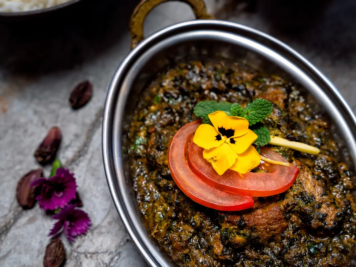 Sagwala aux épinards et à la viande, servi dans un plat en inox